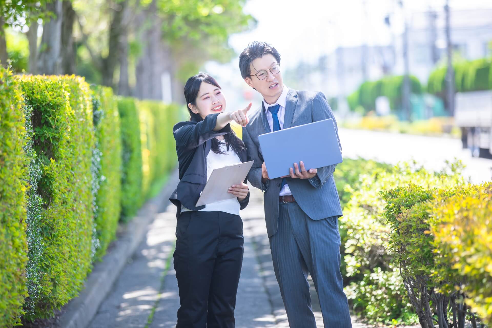 道を指差して説明するビジネスパーソン